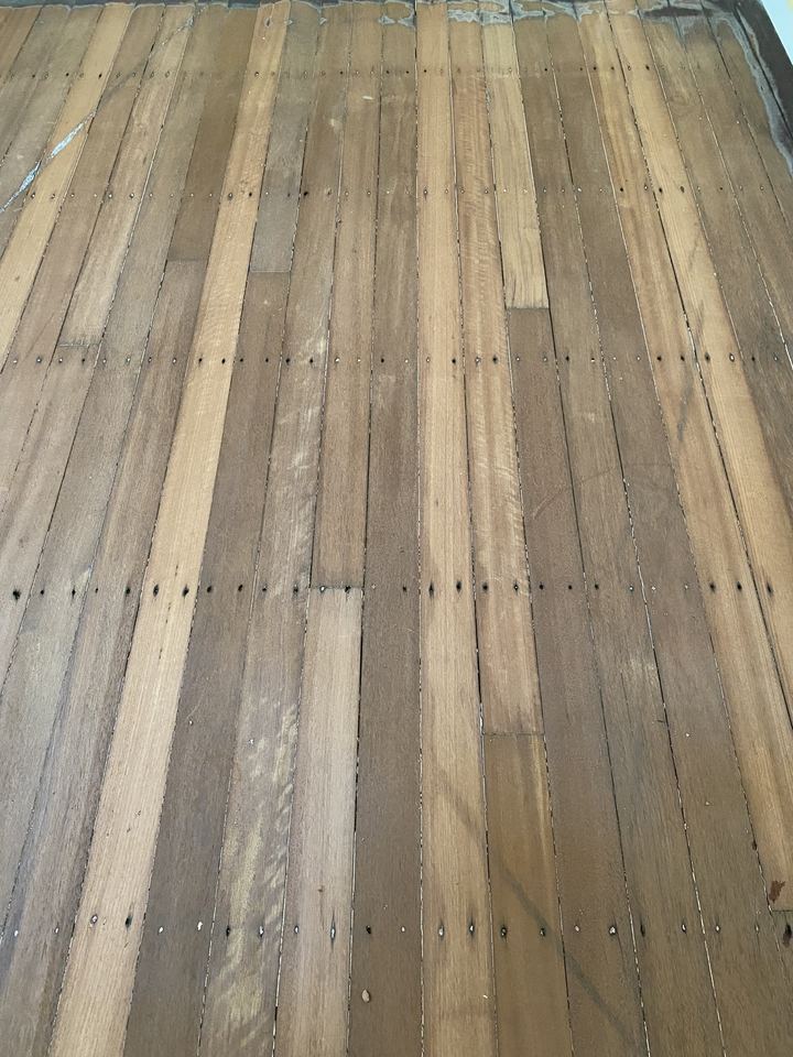 Weathered grey deck boards before restoration.
