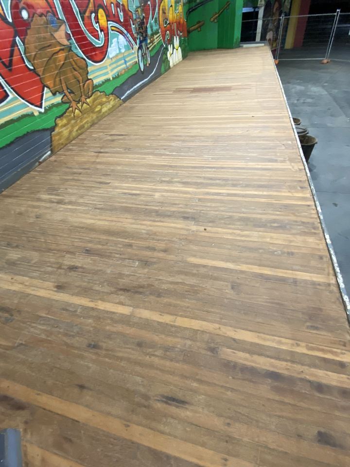 Long timber deck alongside a painted mural wall.