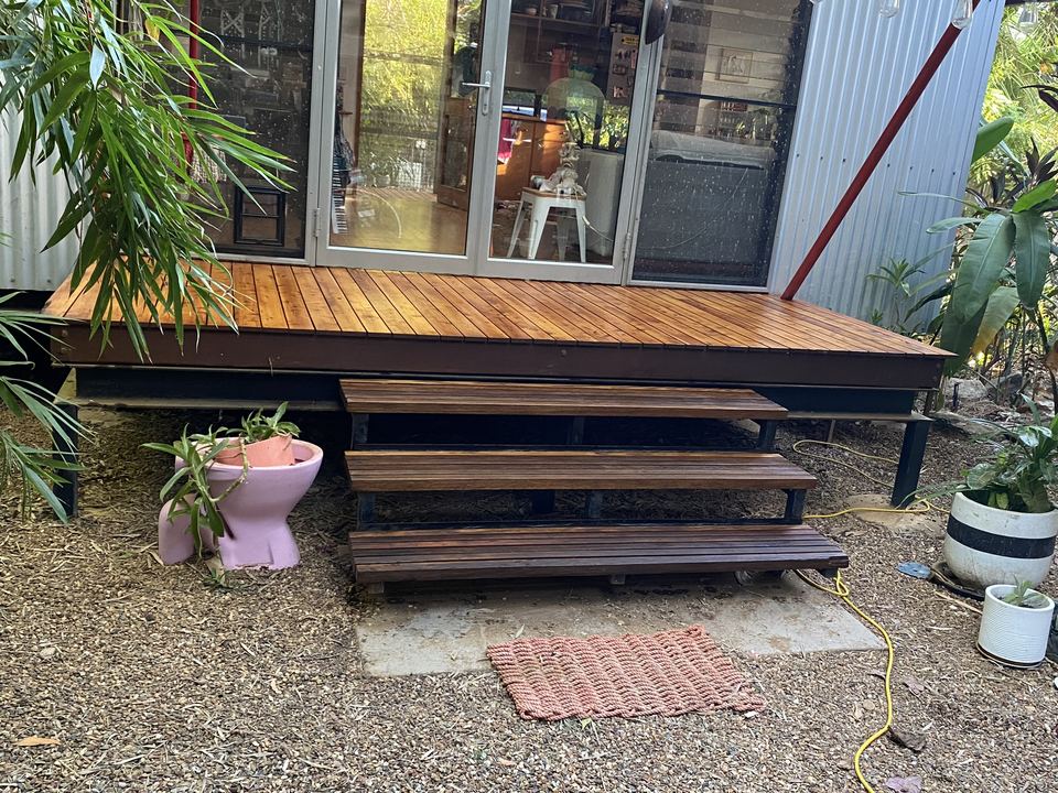 Timber deck and steps with a garden in front.