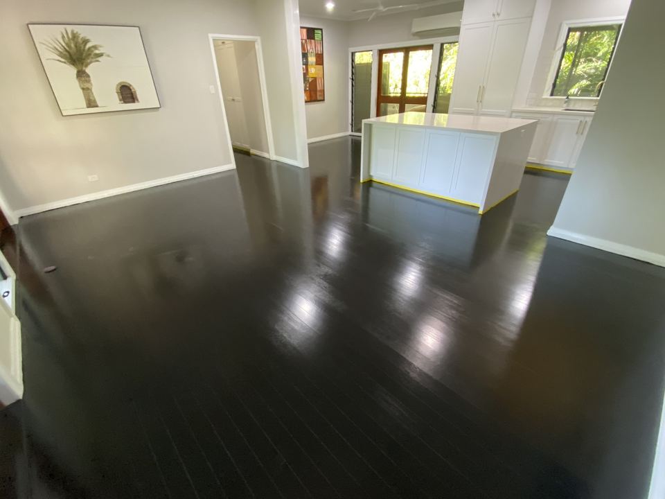 Open-plan living area with a glossy black timber floor.