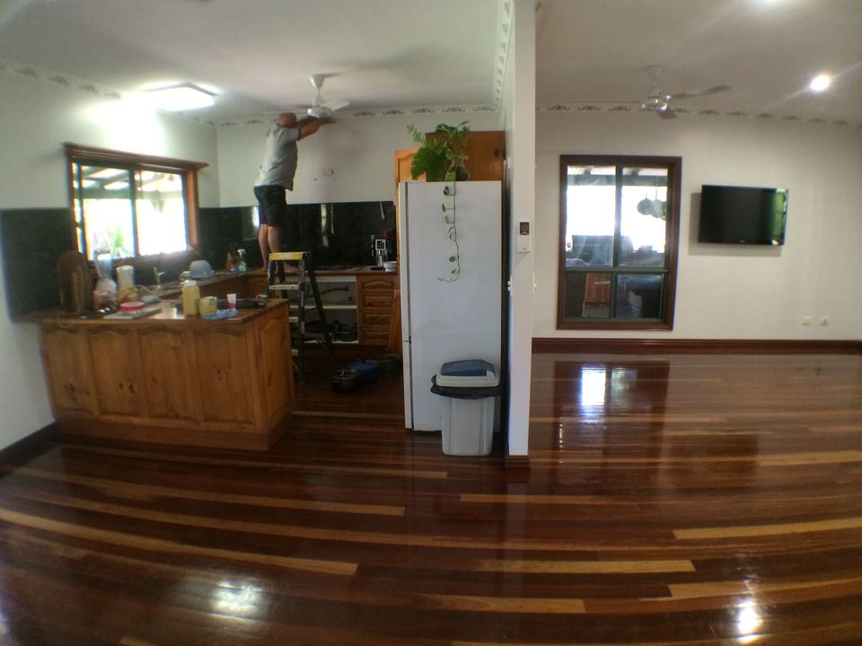Polished hardwood floor running through an open kitchen and living area.