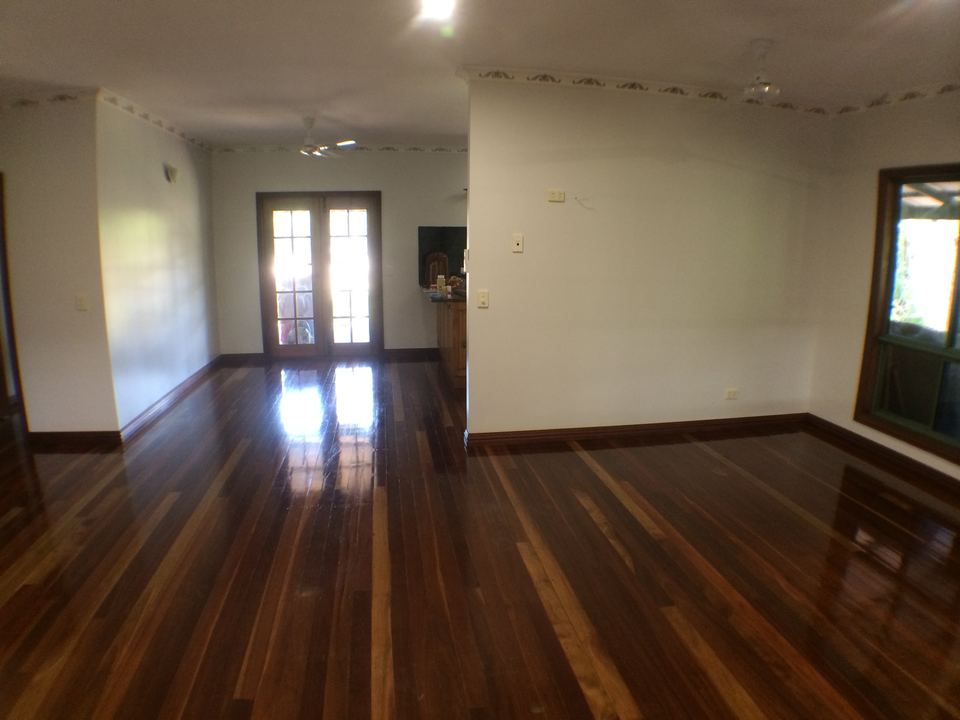 Freshly polished hardwood boards in an empty room with white walls.