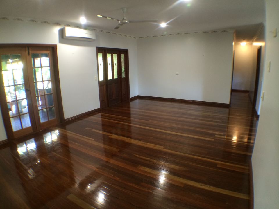 Glossy hardwood floor beneath French doors and a ceiling fan.