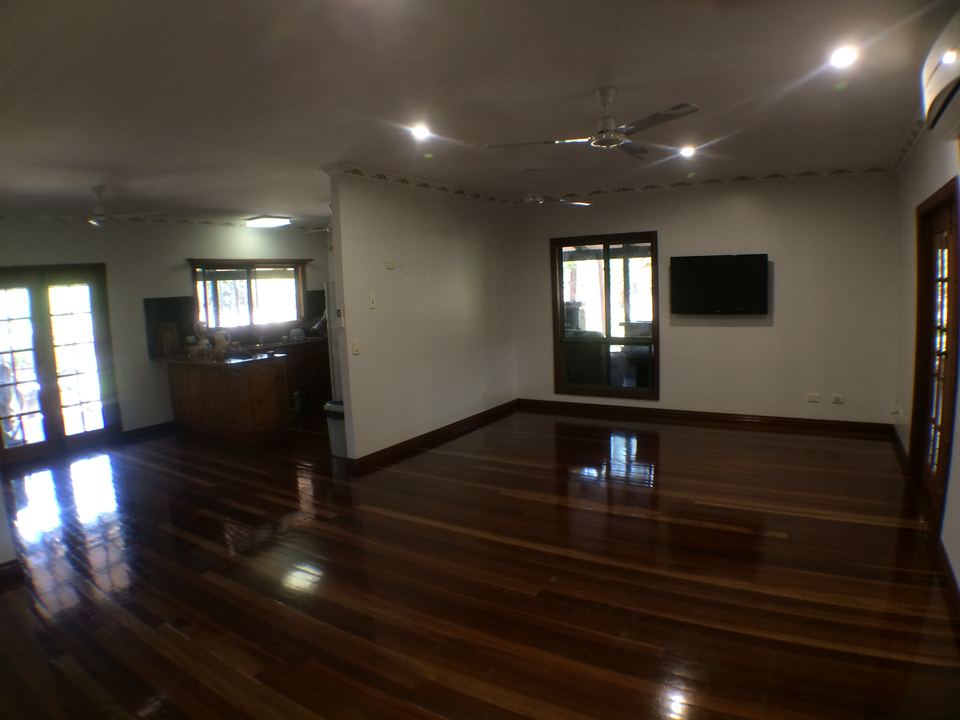 Long run of polished hardwood floor through a bright open room.