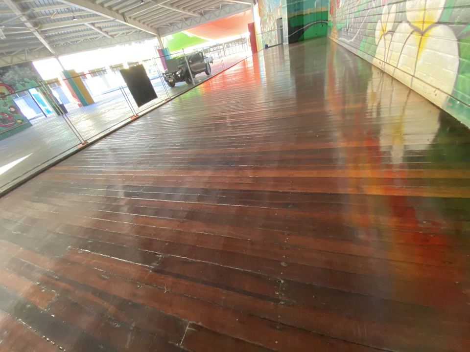High-gloss hardwood floor reflecting a colourful painted mural.