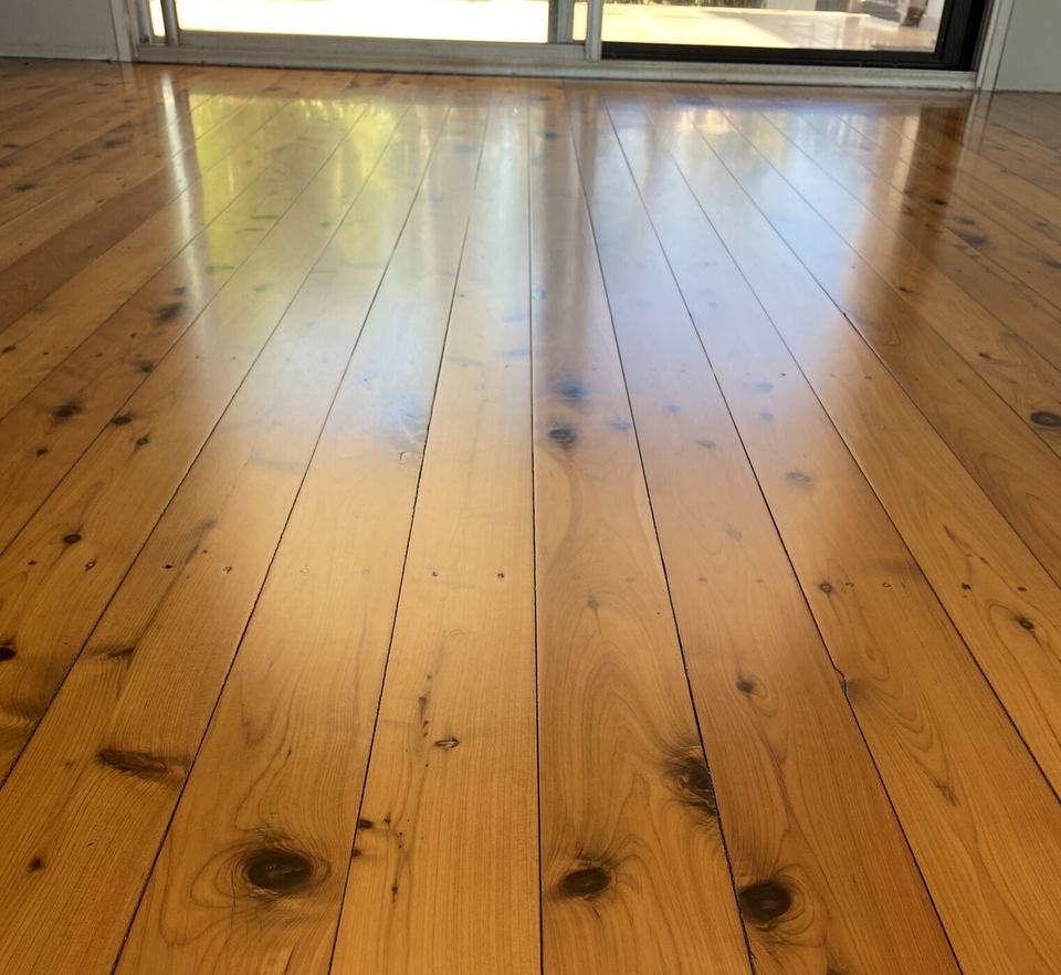 Close view of glowing polished pine boards with natural knots.