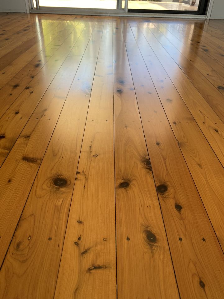 Polished pine boards with dark knots, seen from above.