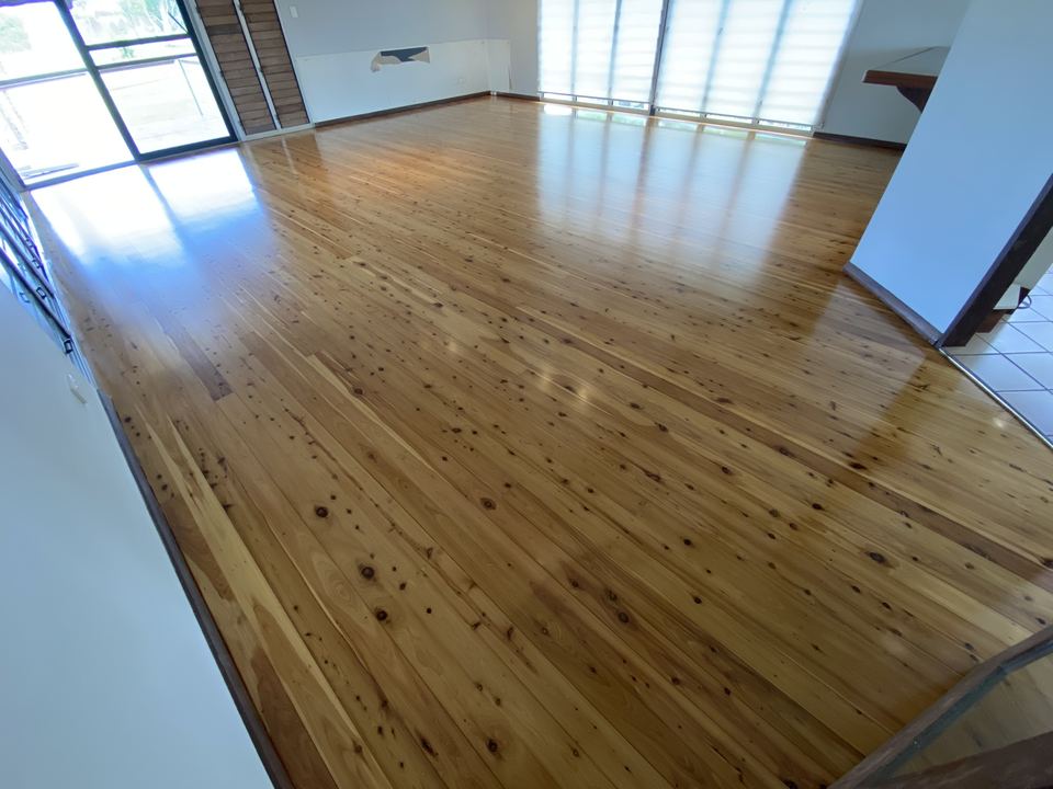Polished golden timber floor beside floor-to-ceiling windows.