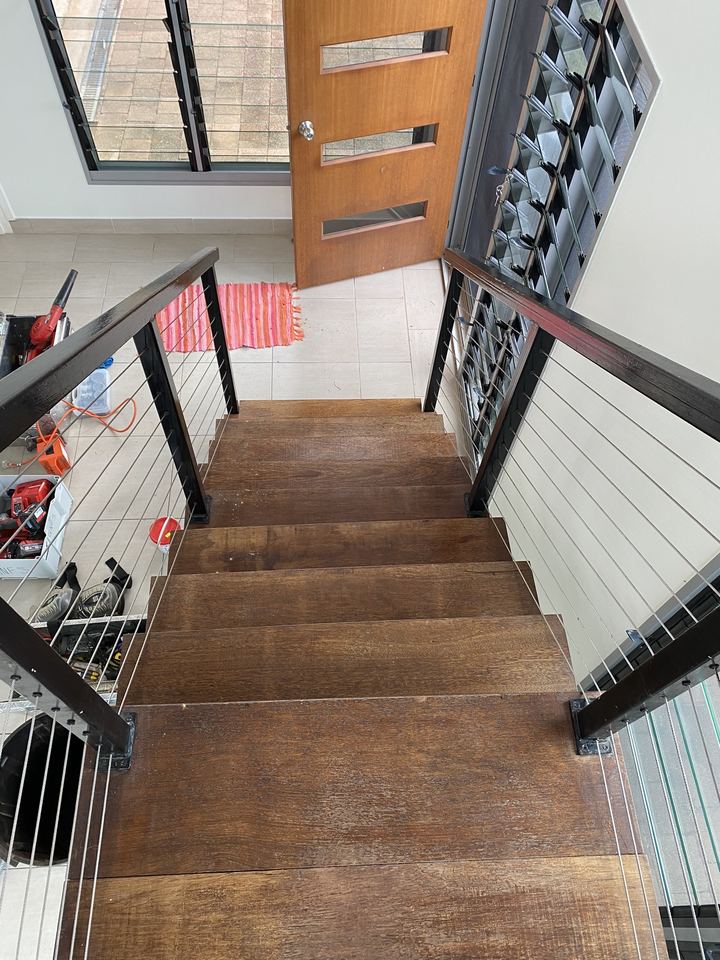 Staircase from above, with sanded timber treads and a cable balustrade.